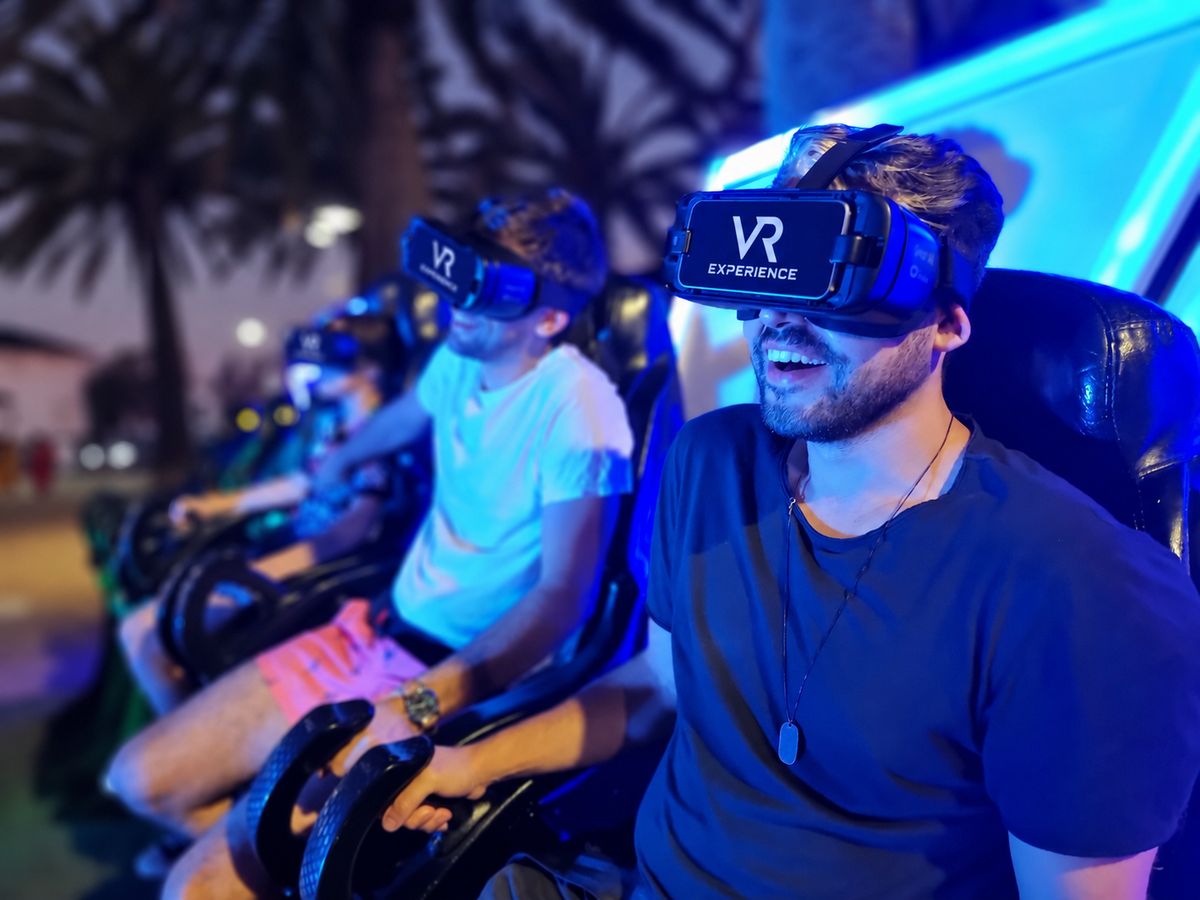 Hombre sonriendo con el visor de VR Experience puesto en una butaca 4D