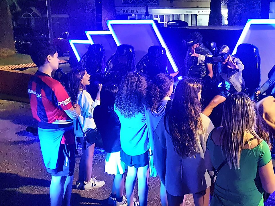 Chicos mirando el cine de noche, con las flechas azules encendidas